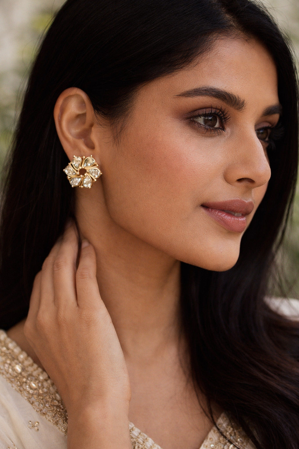 Woman wearing a decorative earring with a blurred natural background