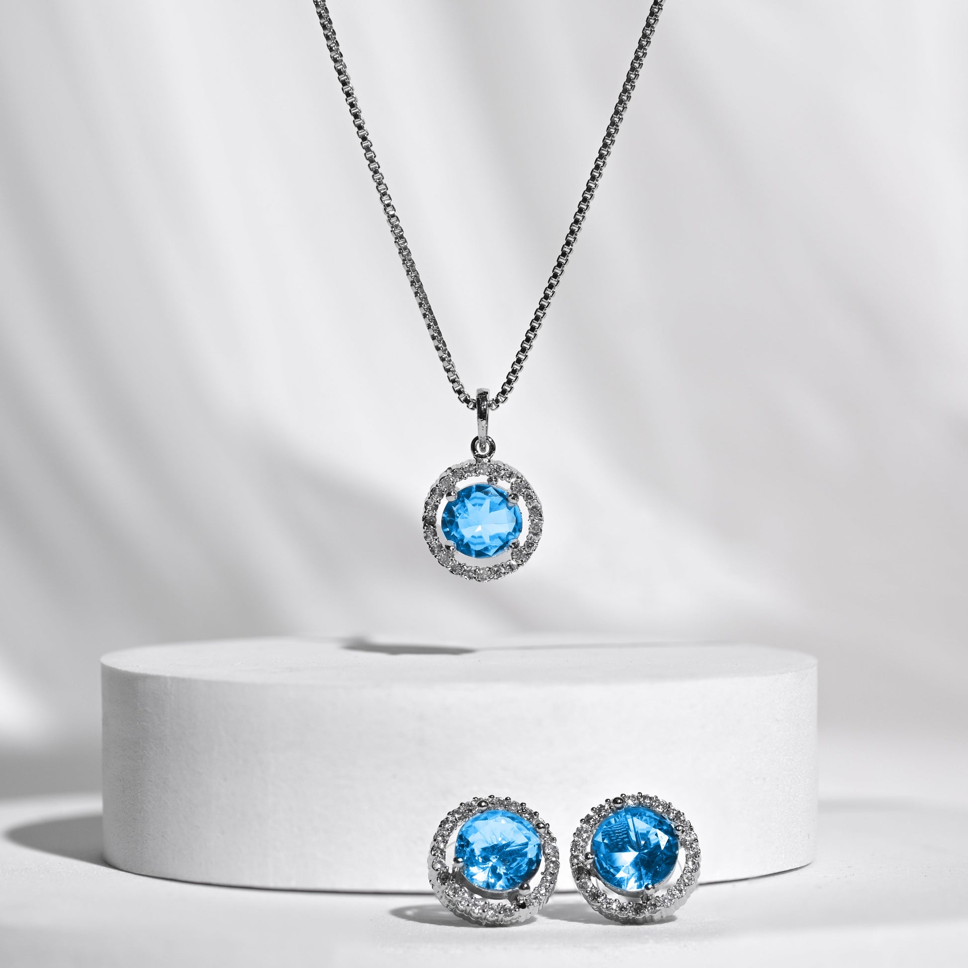 Silver jewelry set with blue gemstones on a white background