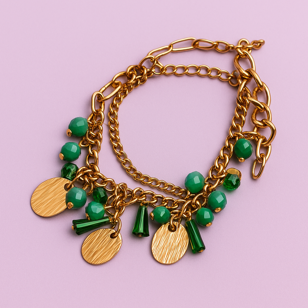 Gold bracelet with green beads on a pink background