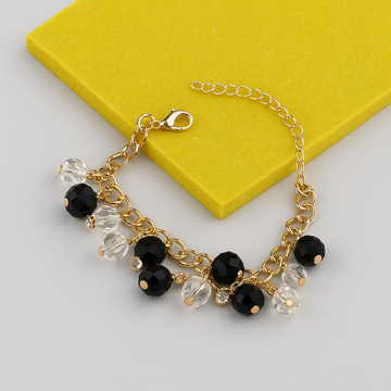 Bracelet with black and clear beads on a yellow box