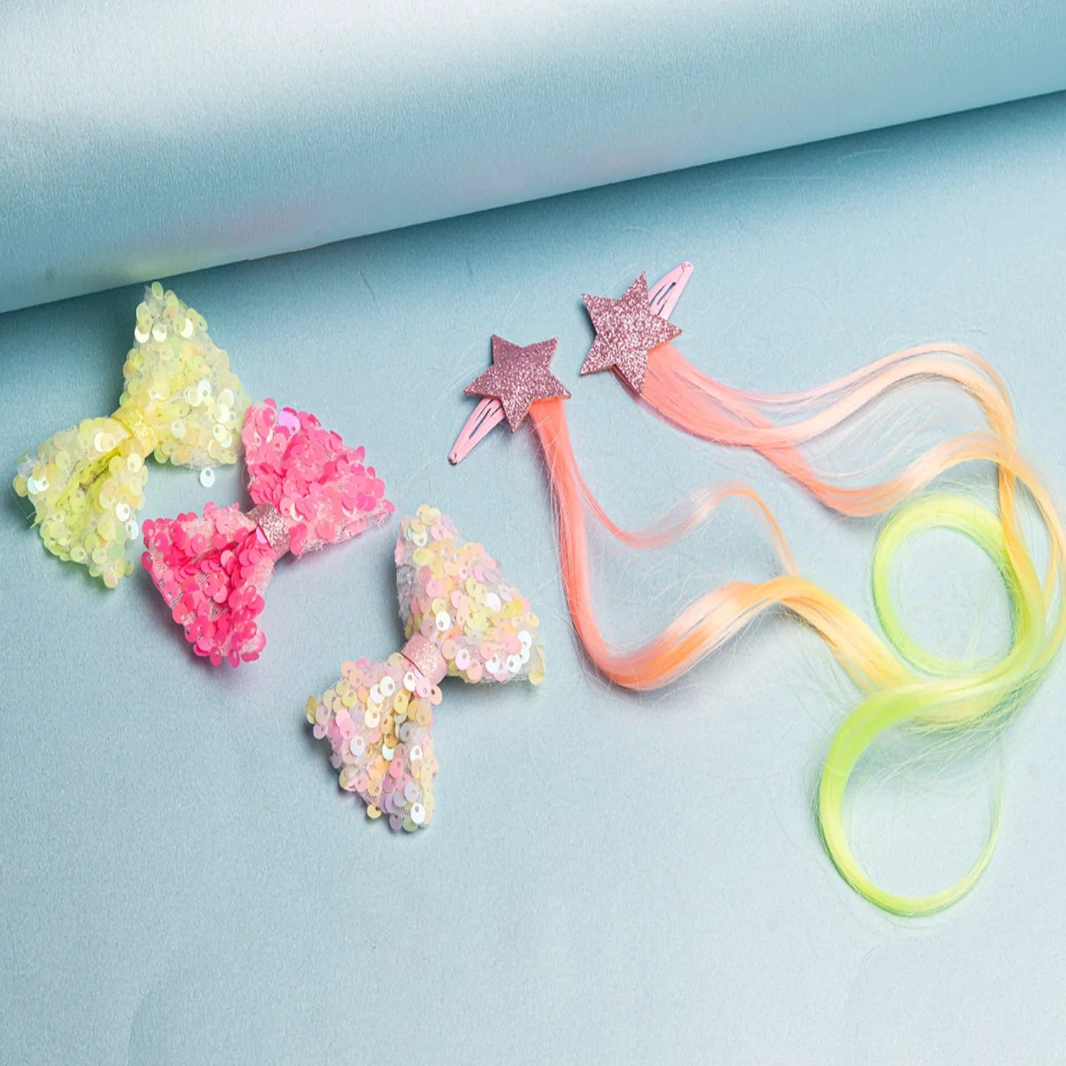 A set of colorful hair clips with star shapes and bows on a blue background.