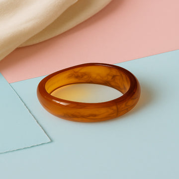 Brown bangle on a pastel background