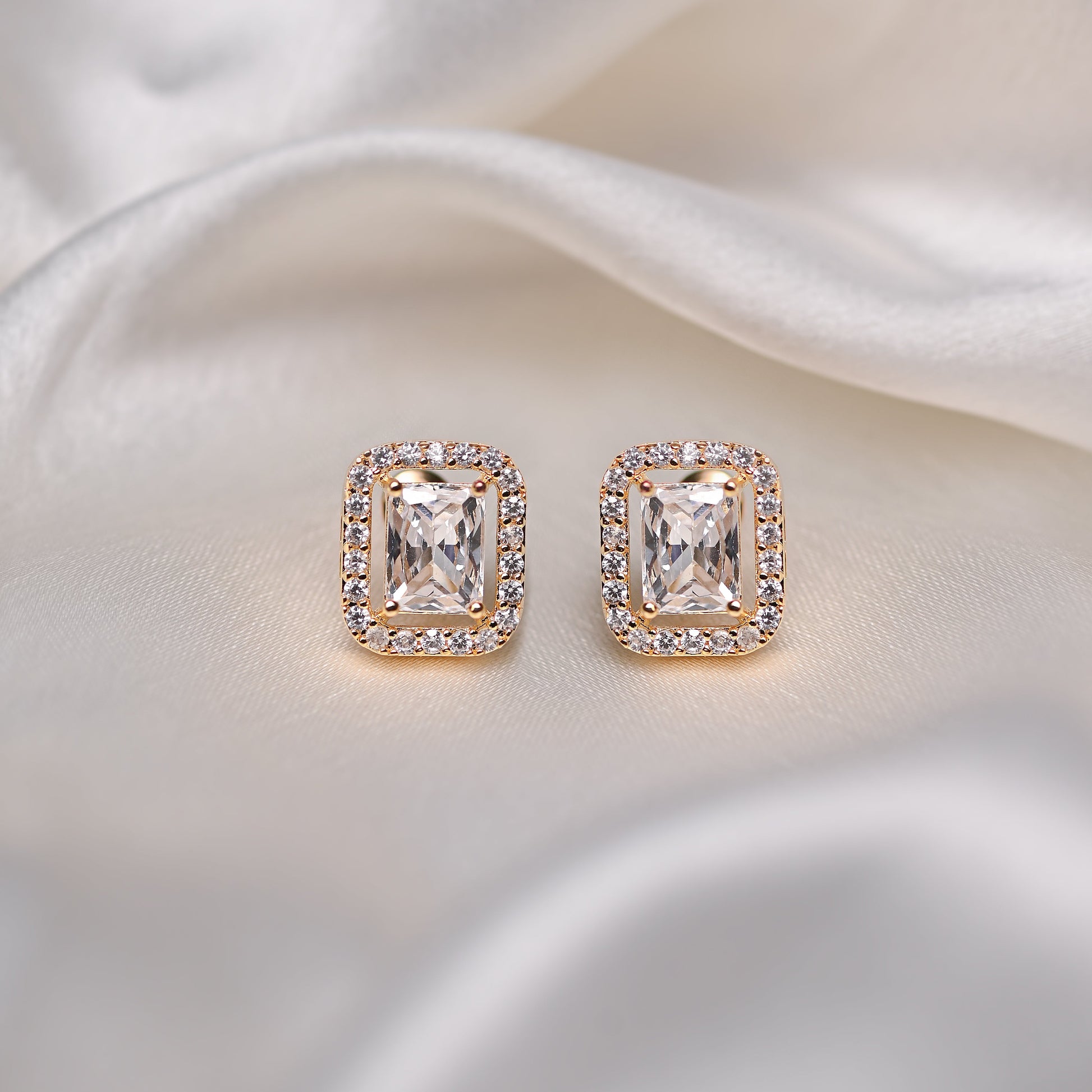 Pair of diamond earrings on a satin surface