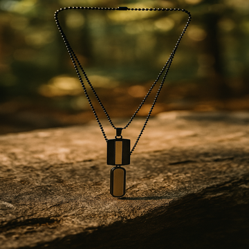Black beaded necklace with two rectangular pendants on a wooden surface