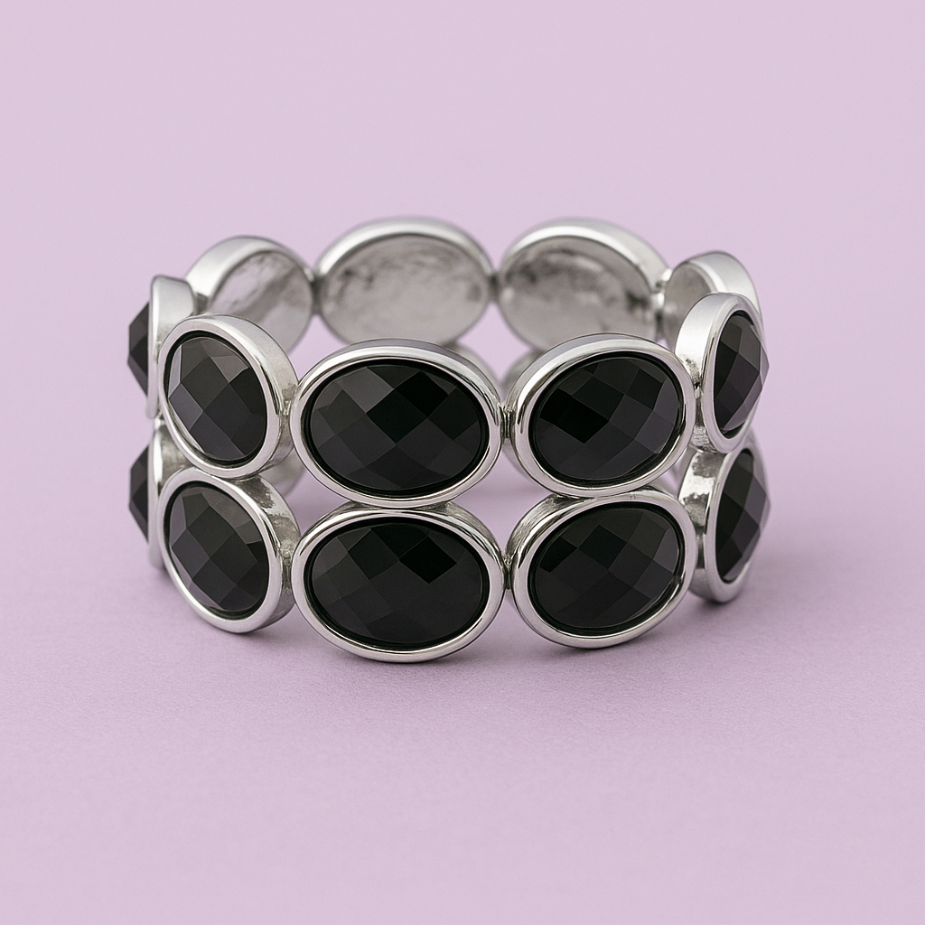Silver bracelet with black beads on a light purple background