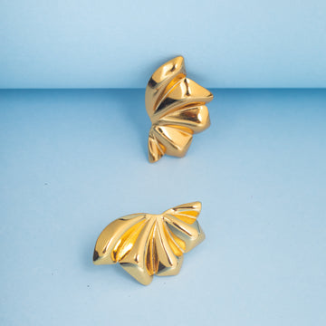 Pair of gold earrings on a light blue background