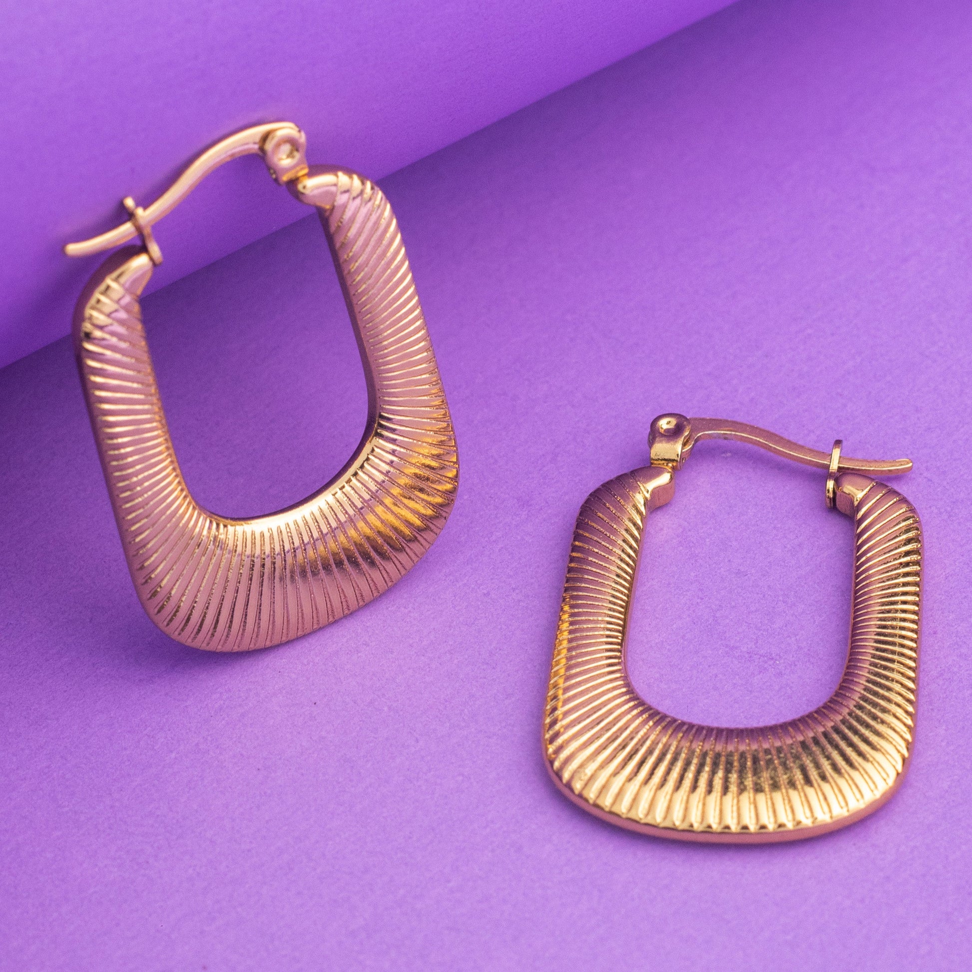 Gold Hoop Earring On A purple Background