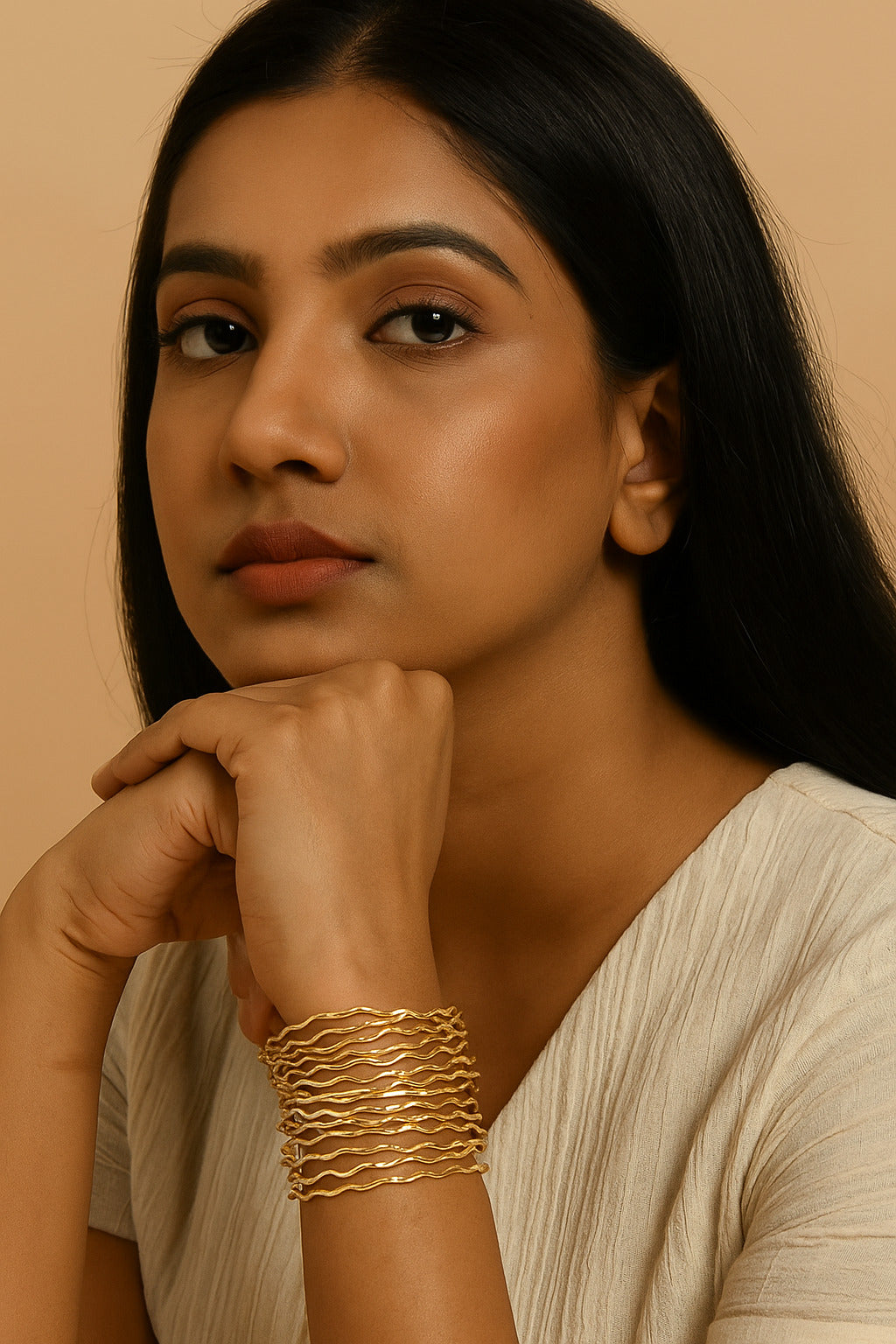 Woman wearing a gold bracelet on a beige background