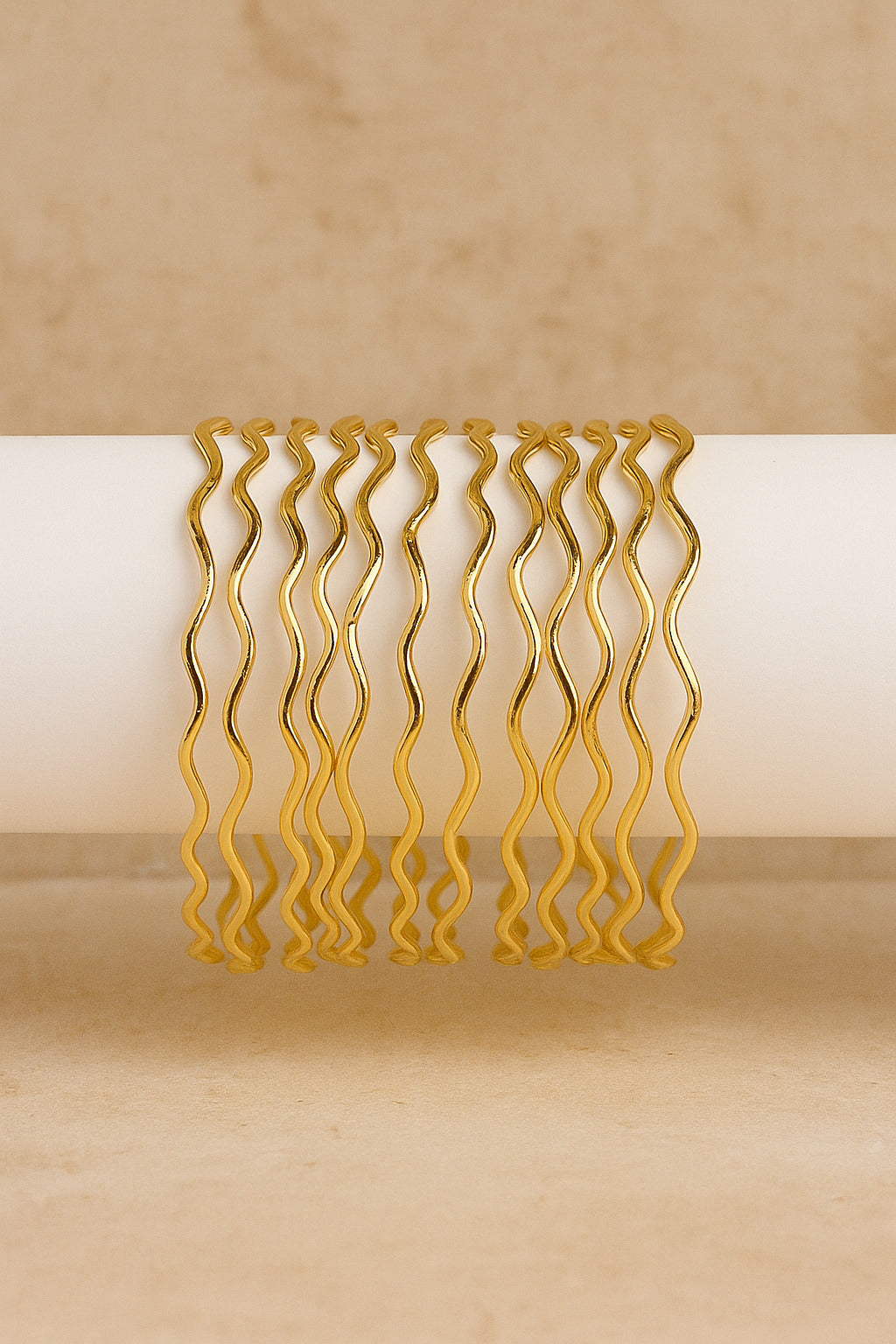 Set of gold hair clips with wavy design on a beige background