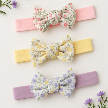 Three floral headbands with different colored bands on a light background