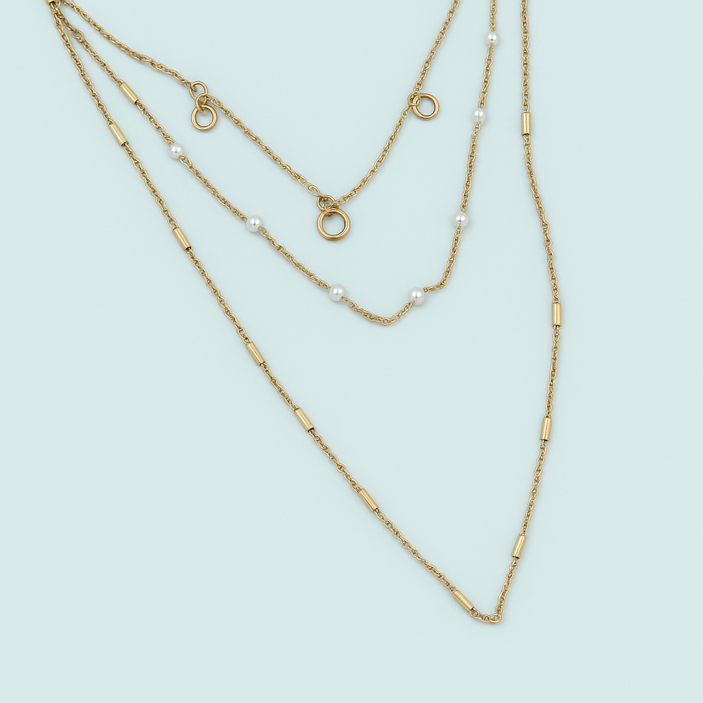 Two gold necklaces on a light blue background