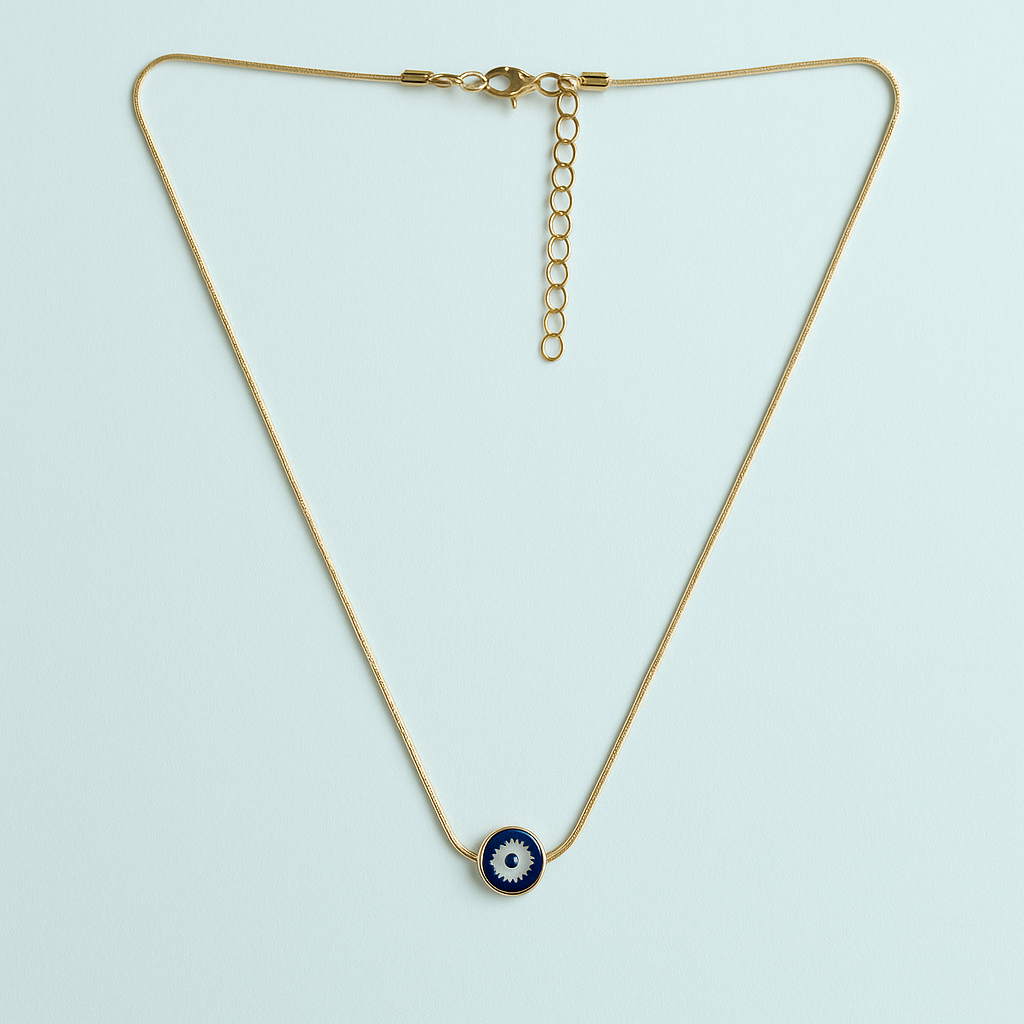 Gold necklace with a blue evil eye pendant on a light blue background