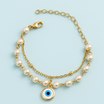 Gold bracelet with pearl beads and a blue evil eye charm on a light blue background