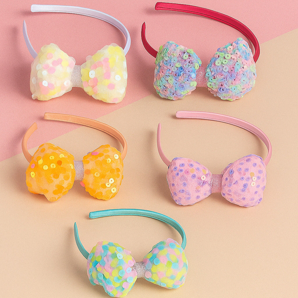Set of colorful sequin bow headbands on a pink and beige background