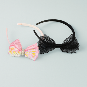 Two headbands with decorative bows on a light blue background