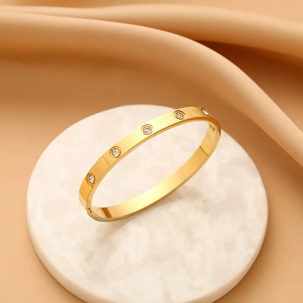 Gold bracelet with small diamonds on a beige fabric background
