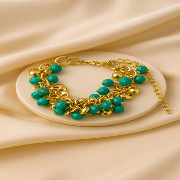 Gold bracelet with turquoise beads on a beige fabric background