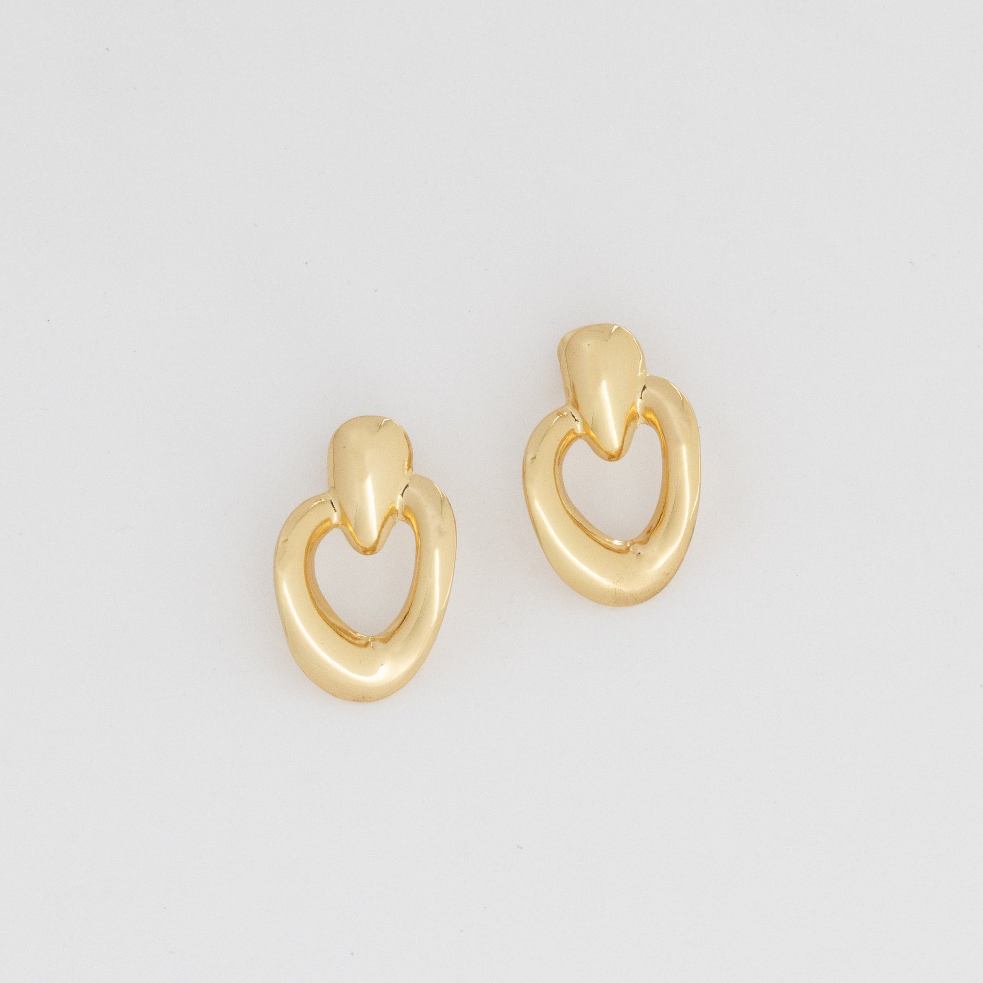 Pair of gold hoop earrings on a light gray background
