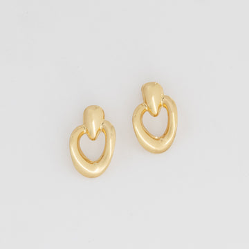 Pair of gold hoop earrings on a light gray background