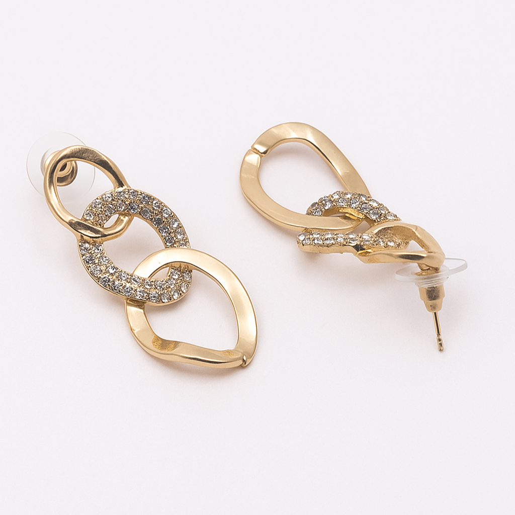 Gold earrings with intricate designs on a white background