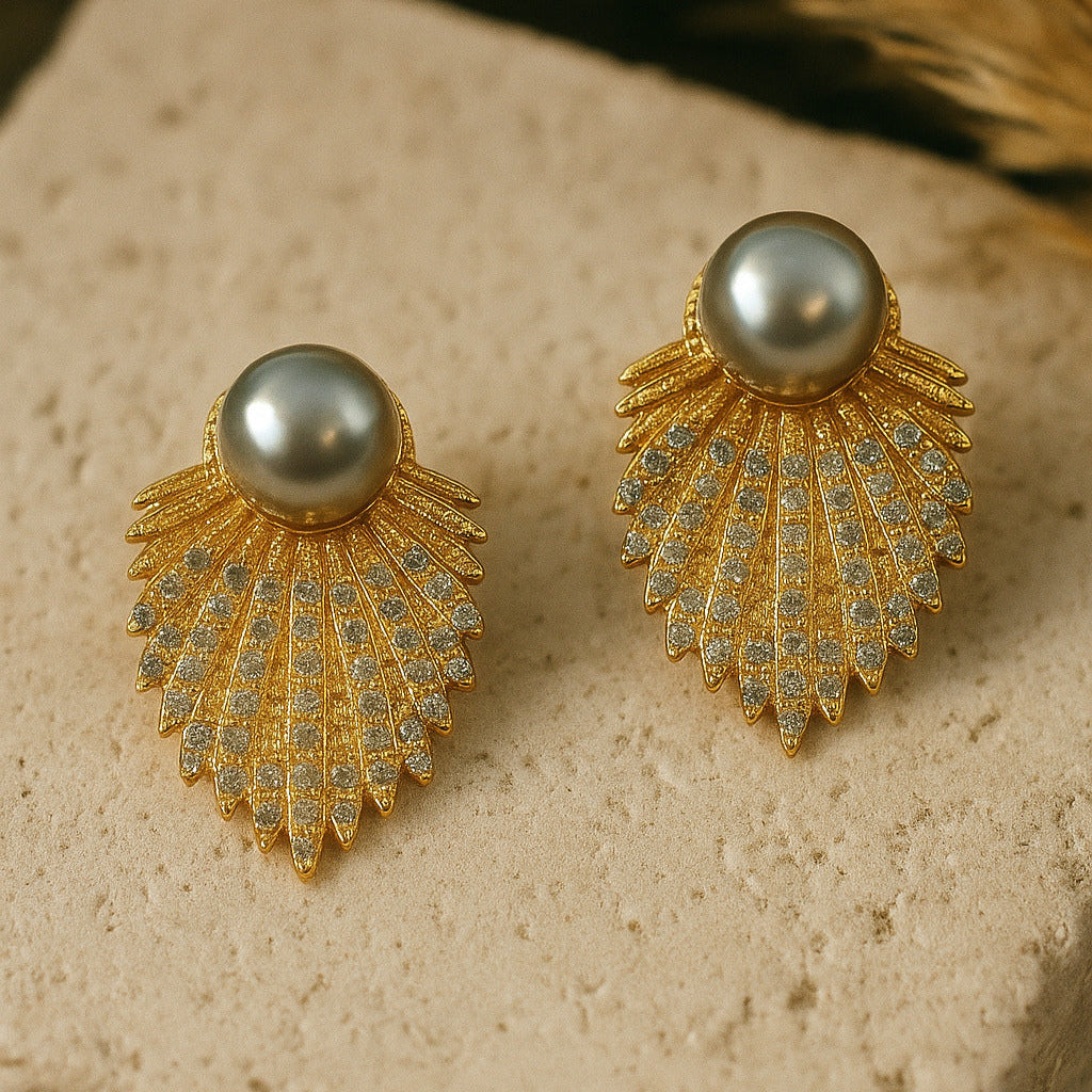 Gold earrings with pearl-like stones on a textured surface
