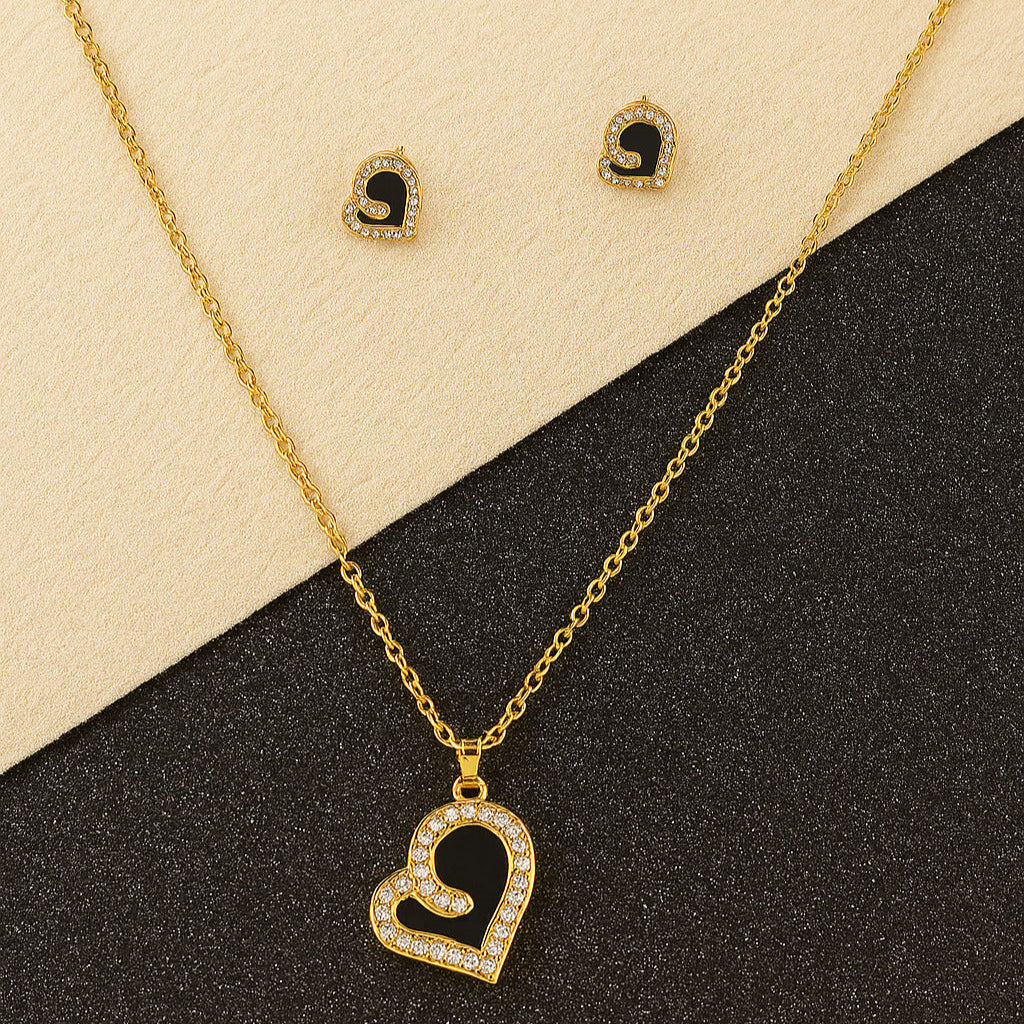 Gold necklace with heart pendant and matching earrings on a black and beige background