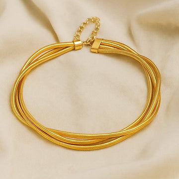 Gold necklace on a beige fabric background