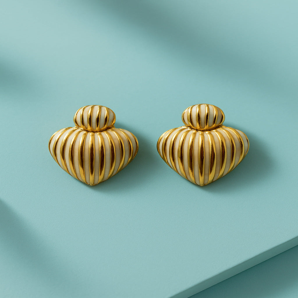 Pair of gold heart-shaped earrings on a light blue background