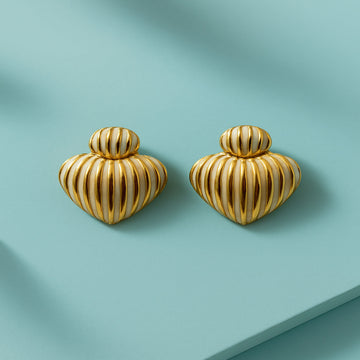 Pair of gold heart-shaped earrings on a light blue background
