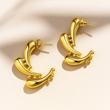 Pair of gold hoop earrings on a beige background