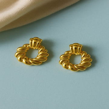 Pair of gold hoop earrings on a light blue background