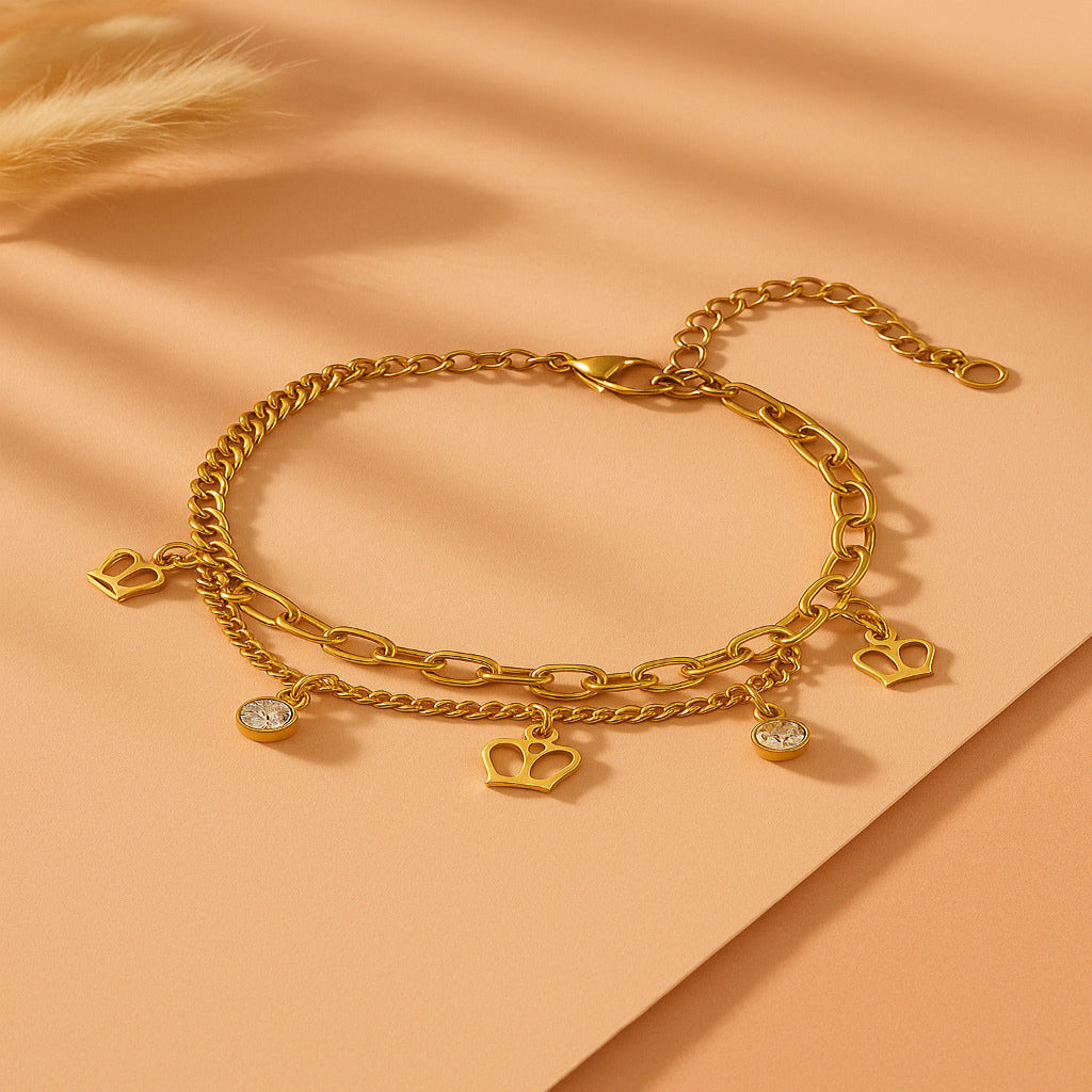 Gold chain bracelet with charms on a peach background