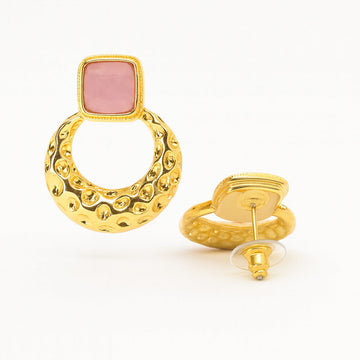 Gold earring with pink stone on a white background