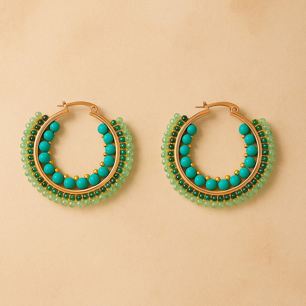 Gold hoop earrings with turquoise and green beads on a beige background