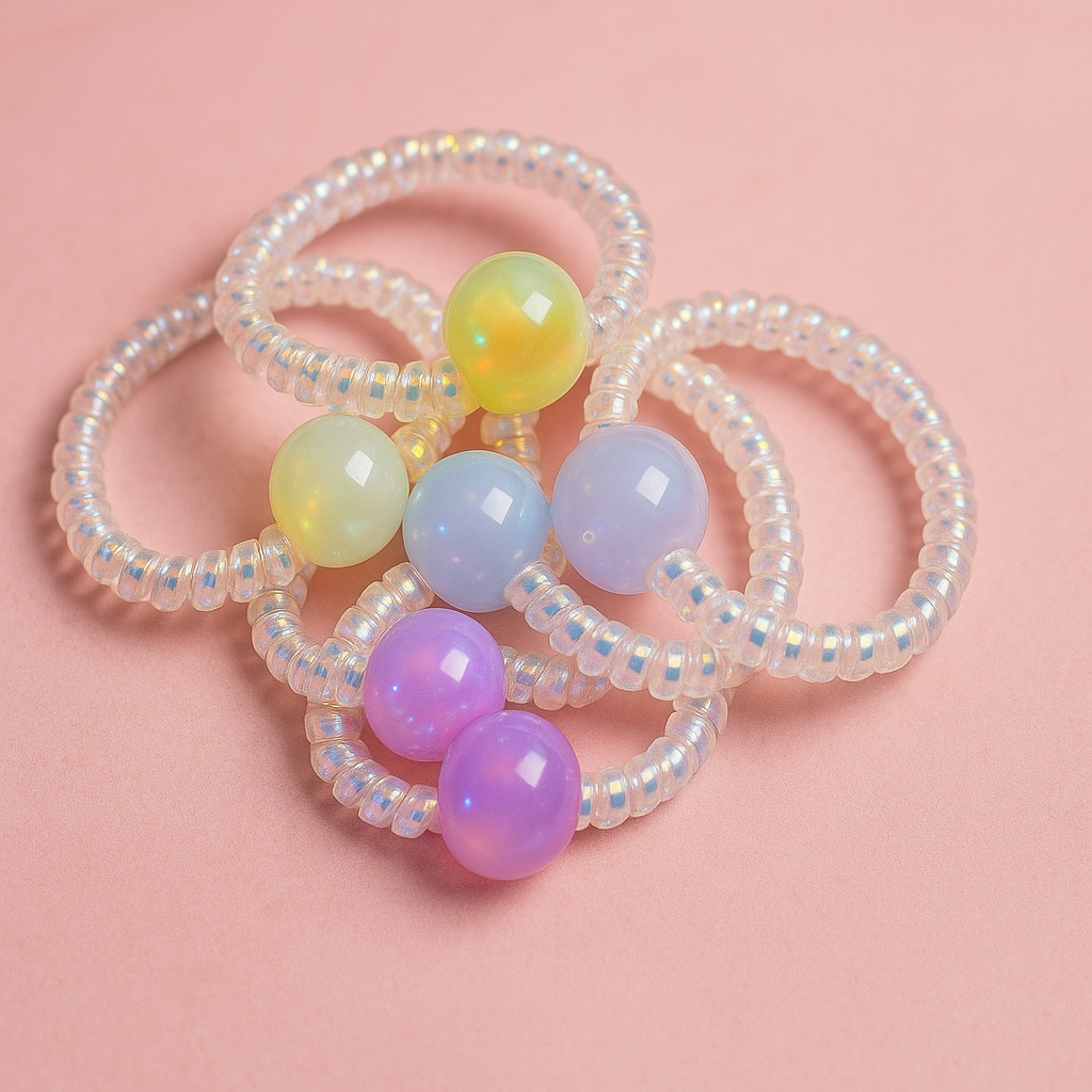Set of beaded hair ties with colorful beads on a pink background