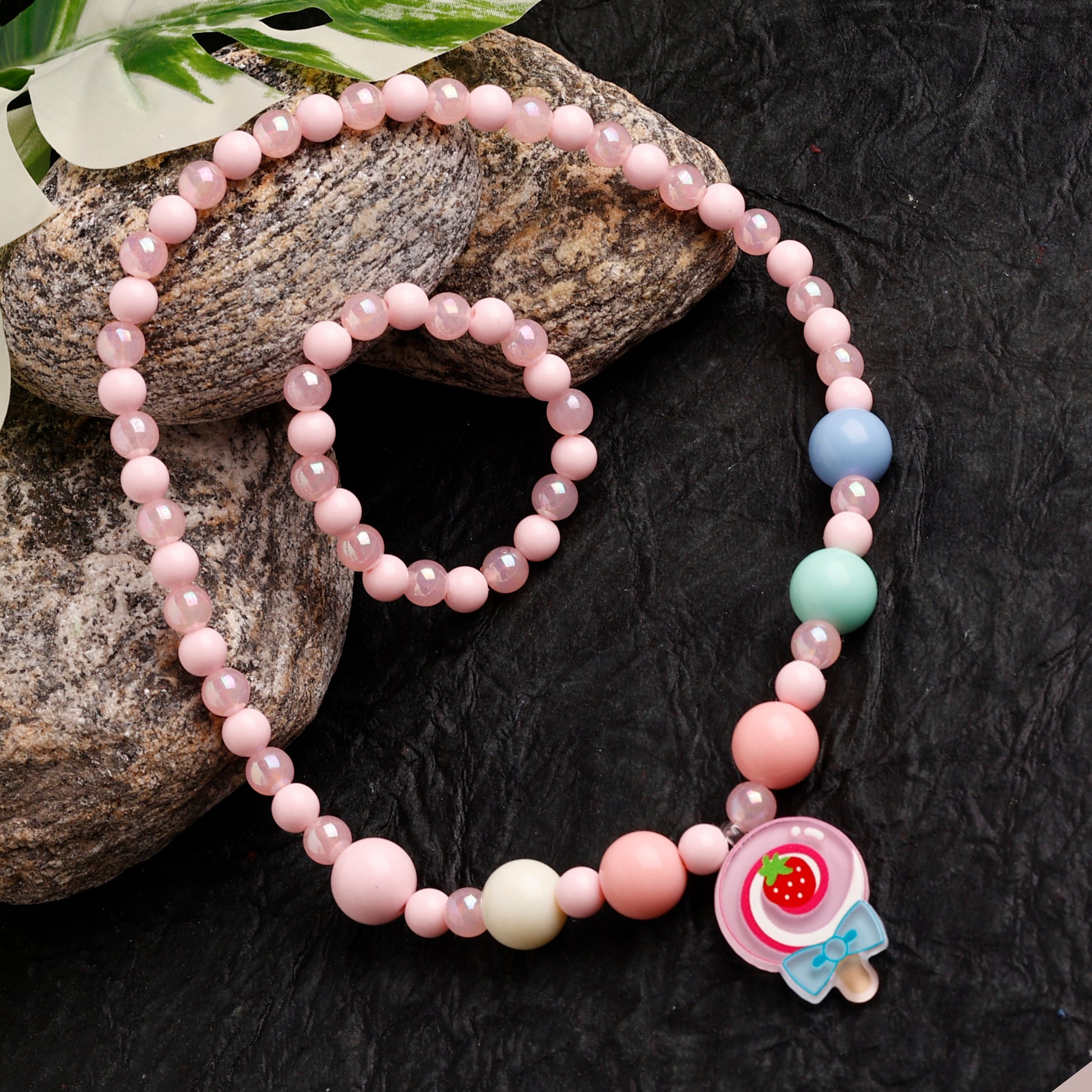 Beaded bracelet with colorful beads and a character charm on a dark textured surface.