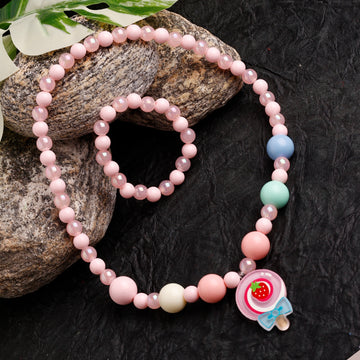 Beaded bracelet with colorful beads and a character charm on a dark textured surface.