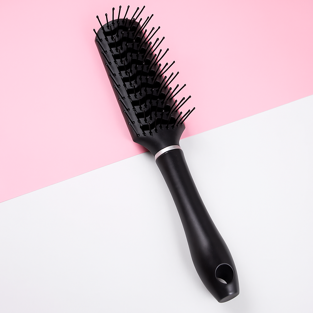 Black hairbrush on a pink and white background
