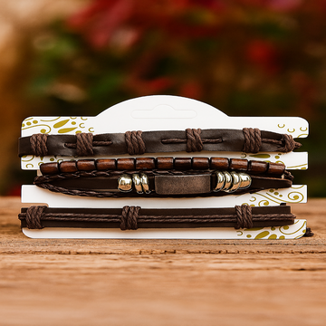 Stack of leather bracelets with metal accents on a decorative stand with a blurred floral background.