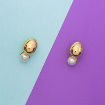 Gold and pearl earrings on a two-tone blue and purple background