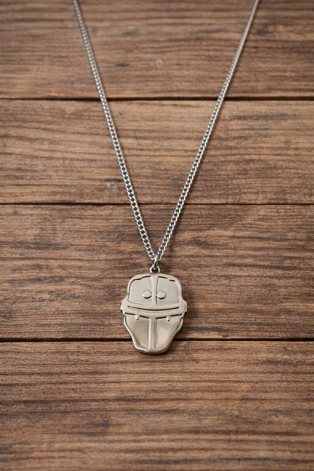 Silver necklace with a pendant on a wooden surface
