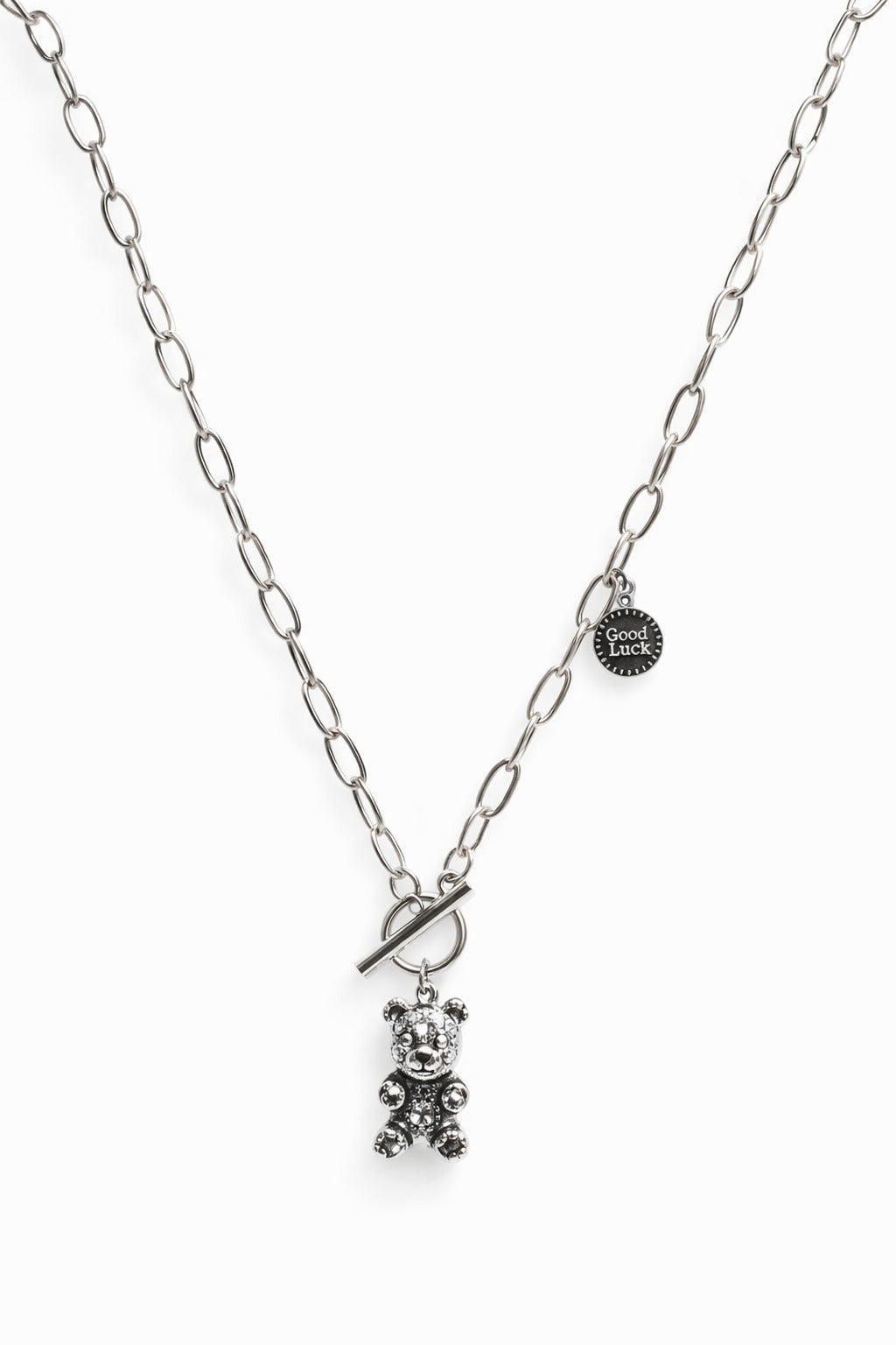 Silver necklace with a teddy bear pendant on a white background