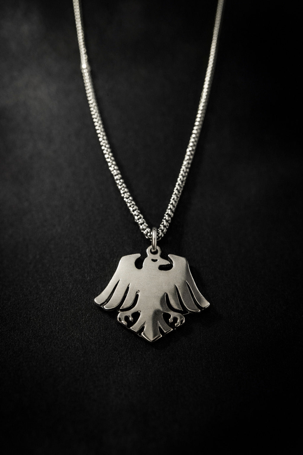 Silver necklace with a unique pendant on a dark background