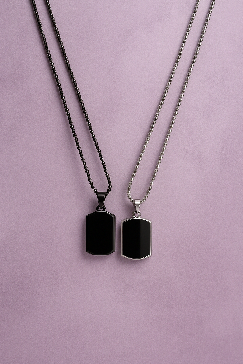 Two black pendant necklaces on a light purple background