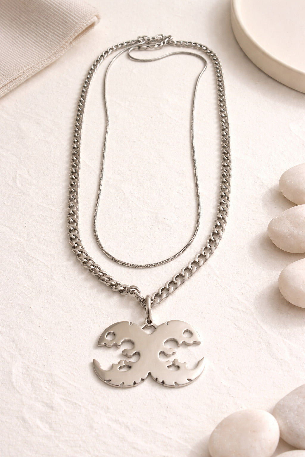 Silver necklace with a pendant on a light surface