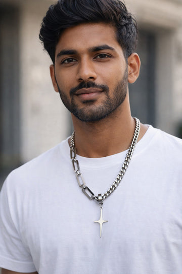 Man wearing a white t-shirt and chain necklace with a star pendant.