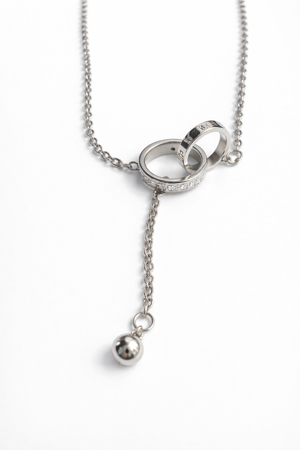 Silver necklace with rings and a pendant on a white background