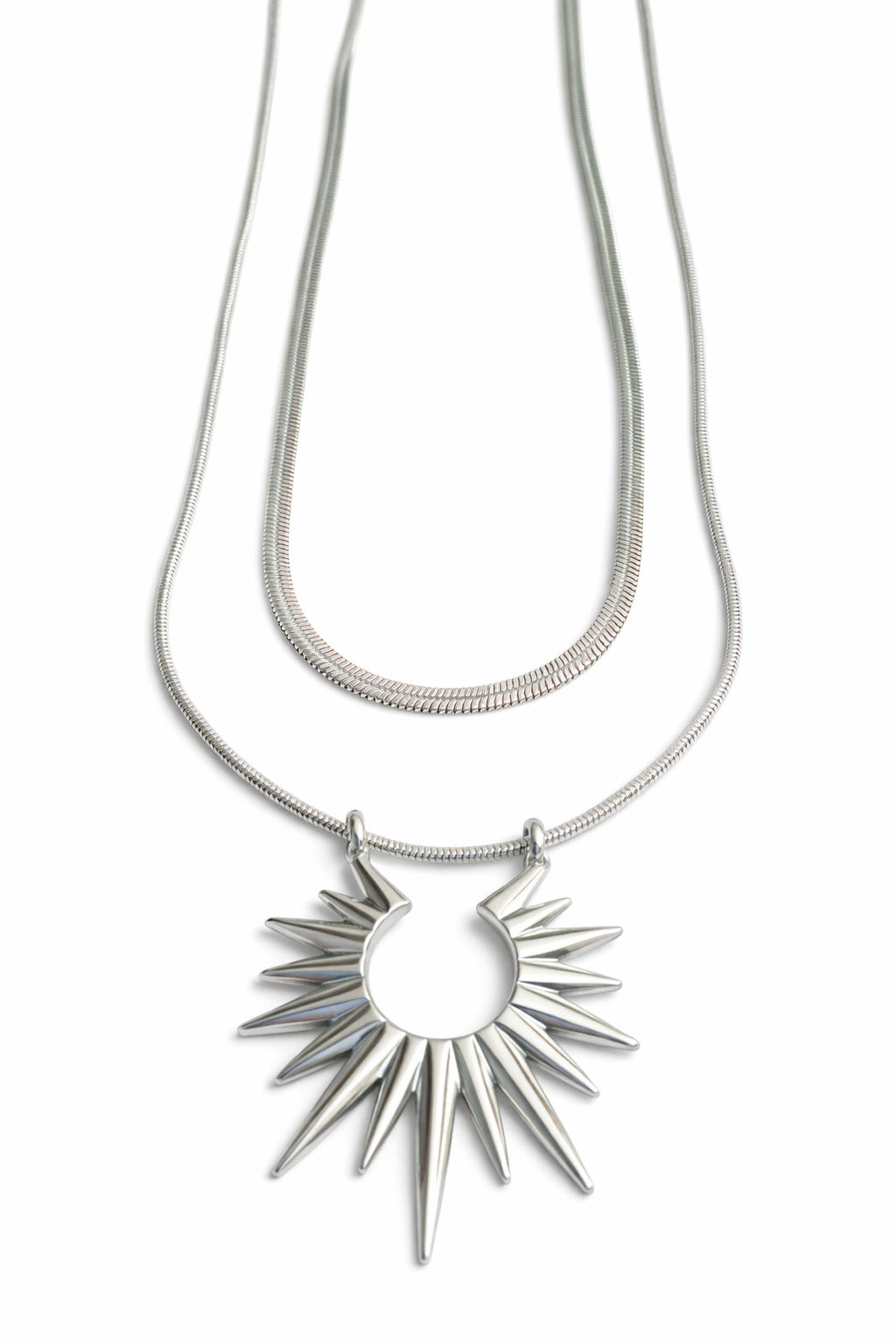 Silver necklace with a sunburst pendant on a white background