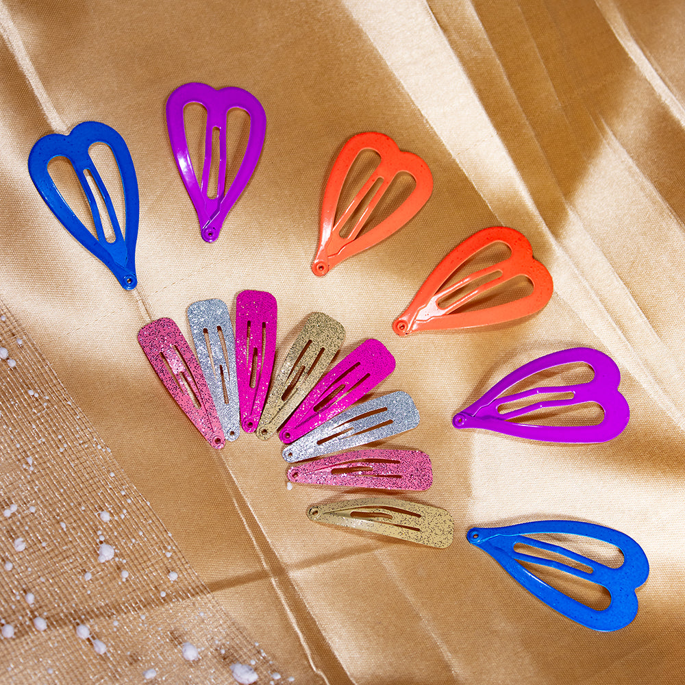 A collection of heart-shaped tic tac hair clips in various colors including blue, red, pink, purple, and silver, displayed on a golden background.