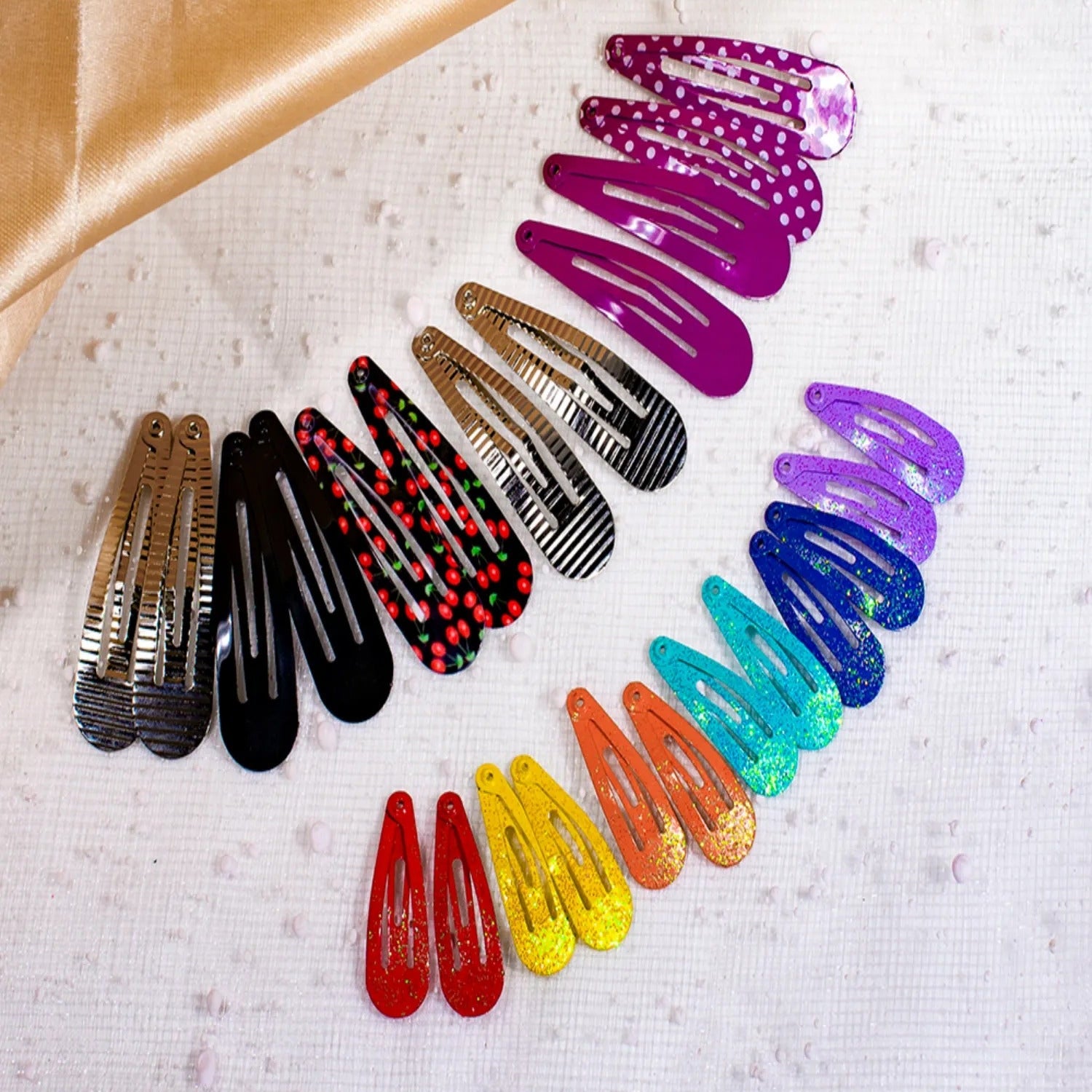 Assorted colorful hair clips on a textured surface with a brown fabric background.
